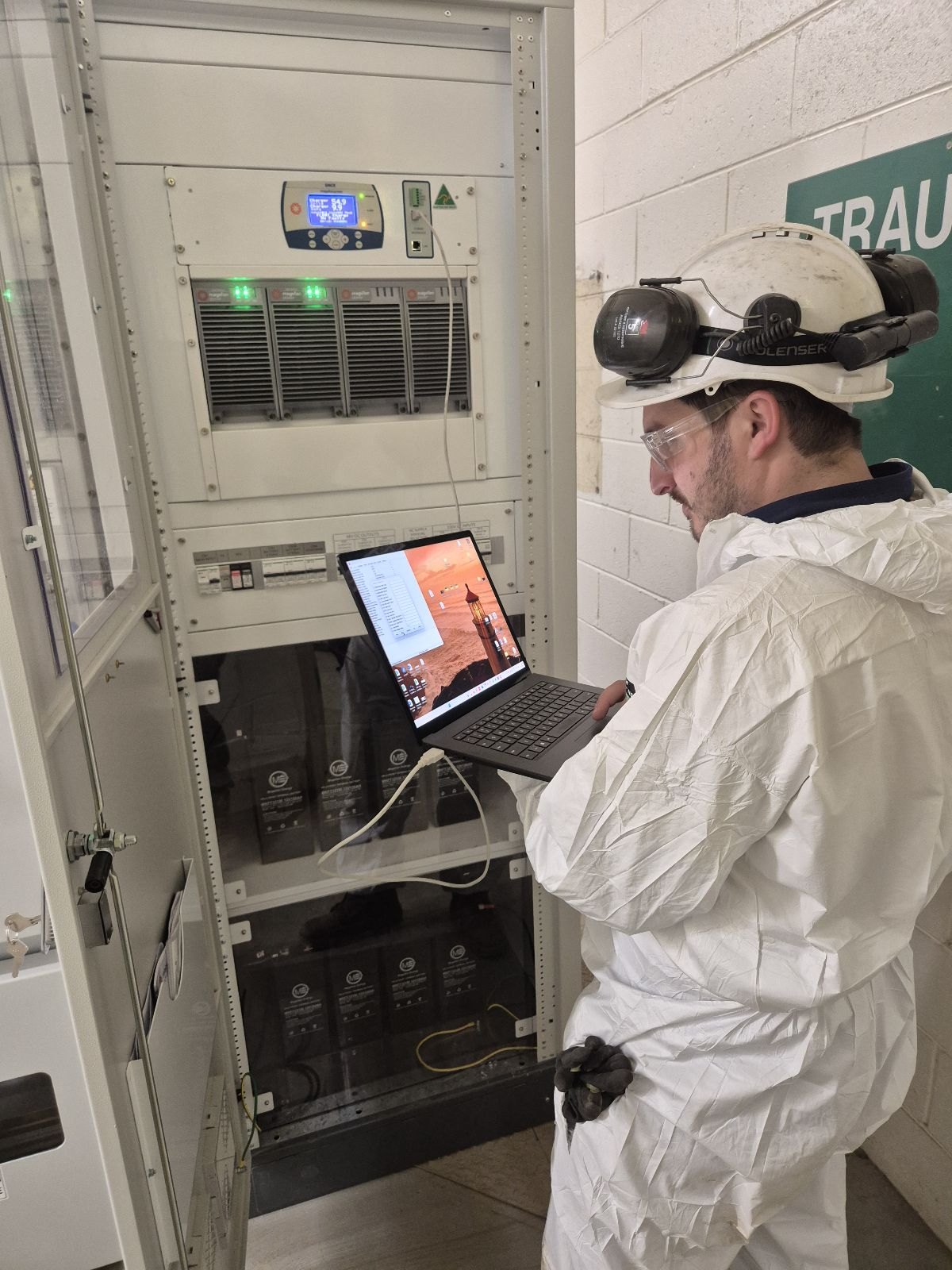 Technician checking a DC charger panel on a laptop